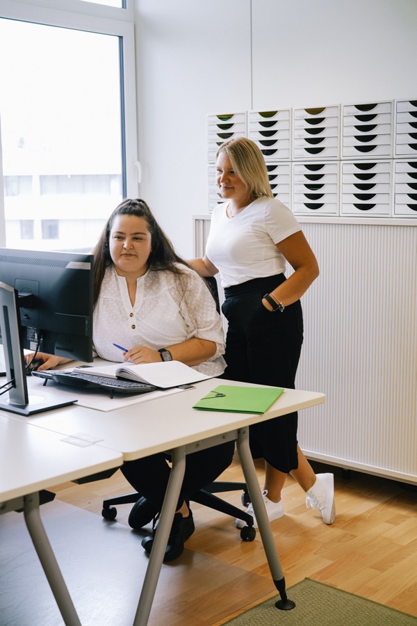 Zwei Mitarbeiterinnen von Alltagsdienst Sperling bei der Arbeit am Schreibtisch im Büro