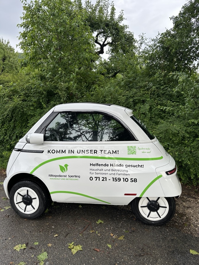 Elektrofahrzeug von Alltagsdienst Sperling mit der Aufschrift Komm in unser Team
